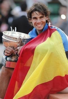  Nadal que posa con la bandera de España tras vencer al suizo Roger Federer en la final del torneo de Roland Garros en París de 2011.