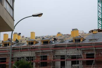 Colocadores de pizarra, trabajando en el tejado de una vivienda en O Barco. (Foto: LUIS BLANCO)