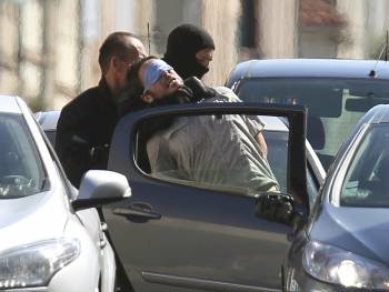 Un policía trata de meter en un coche a uno de los etarras detenidos el pasado martes en Francia. (Foto: JAVIER ETXEZARRETA)