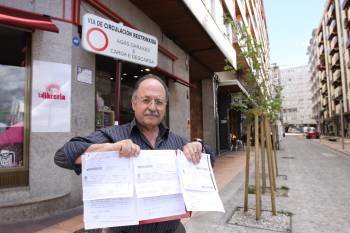 Juan Manuel Álvarez, en la imagen, exhibe la denuncia que le fue impuesta a la entrada de la calle donde vive. (Foto: X. FARIÑAS)