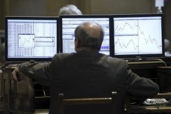 Un visitante observa unos monitores en la Bolsa de Madrid 
