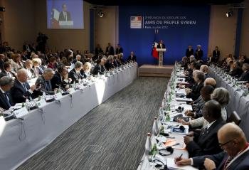 El presidente de Francia Francois Hollande (fondo) pronuncia el discurso de inauguración de la reunión 'Amigos del pueblo de Siria' que se celebra en París