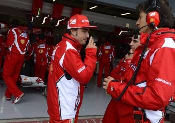 Alonso habla con los miembros del equipo a la espera que escampase. (Foto: NIGEL RODDIS)