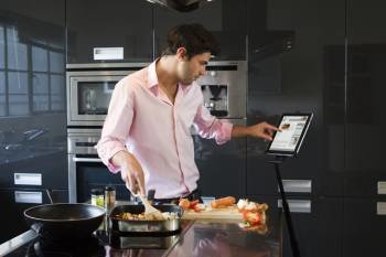Un hombre consulta una receta a través de su tablet mientras cocina. (Foto: ARCHIVO)