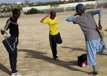 Los corredores somalíes Mohamed Hassan Mohamed (i) y Zamzam Mohamed Farah estiran durante una sesión de entrenamiento en el Estado de Konis, en Mogadiscio. 19/07/2012.- EFE/ Ilyas Ahmed