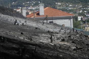 Las llamas llegaron hasta el muro mismo de un chalé, en la imagen, emplazado en las cercanías de Oira. (Foto: M. ÁNGEL)