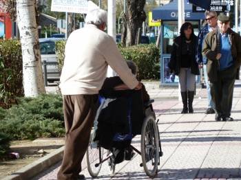 Un hombre empuja la silla de ruedas de una persona dependiente. (Foto: ARCHIVO)