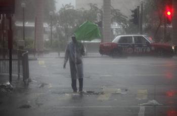 Un hombre trata de combatir la lluvia provocada por el tifón 'Vicente'
