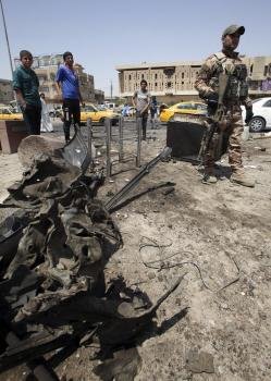  Un soldado inspecciona el escenario del ataque con coche bomba en distrito chií de Sadr City, en Bagdag