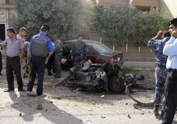 Varios policías iraquíes inspeccionan el escenario del ataque con coche bomba en Kirkuk, al norte de Irak