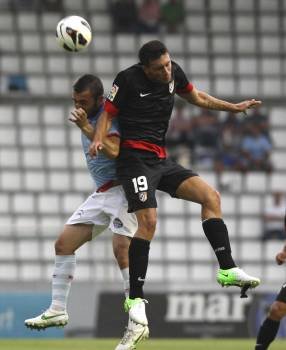 Cristian Bustos (i) lucha por un balón con el futbolista del Atlético de Madrid Borja González. (Foto: SALVADOR SAS)
