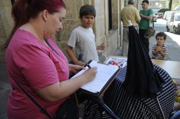 Unha veciña do Carballiño asina o documento na mesa instalada na Praza Maior. (Foto: MARTIÑO PINAL)