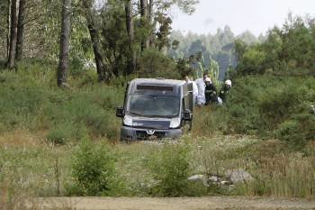 Efectivos de los servicios de emergencias retiran uno de los cuerpos de los pilotos tras el accidente del avión cerca del aeropuerto santiagués. (Foto: XOÁN REY)