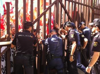 Los policías cierran las puertas para impedir el acceso de los manifestantes al Parlamento. (Foto: X.B.)