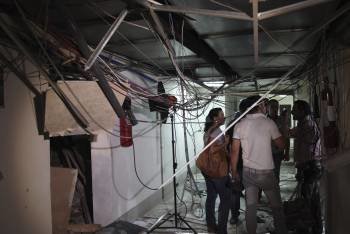 Empleados de la televisión estatal siria, inspeccionan los daños en la sede de sus oficinas en Damasco. (Foto: Y. BADAWI.)