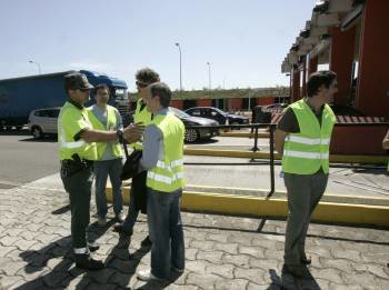 Xoan Carlos Bascuas conversa con un agente de la Guardia Civil en el peaje de Sigueiro. (Foto: XOAN REY)