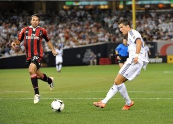 El jugador del Real Madrid Cristiano Ronaldo (d) patea el balón ante Mario Yepes, del AC Milán
