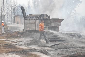 El fuego alcanzó la planta de compostaje, que tuvo que parar la producción. Un operario refresca con agua el terreno y material acumulado. (Foto: LUIS BLANCO)