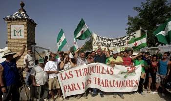 Momento en que los jornaleros abandonan la finca militar 'Las Turquillas'. (Foto: JUAN FERRERAS)