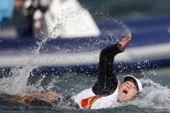 Támara Echegoyen nada detrás de su barco después de ganar la final olímpica. (Foto: EFE)