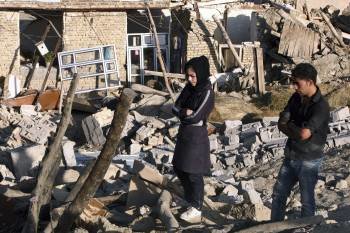 Dos hermanos caminan sobre los escombros de lo que fue su casa en Bajej Baj. (Foto: ABEDIN T.)