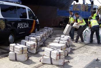 Varios agentes descargan en el puerto de Cádiz la cocaína hallada a bordo del mercante. (Foto: VÍCTOR LÓPEZ)