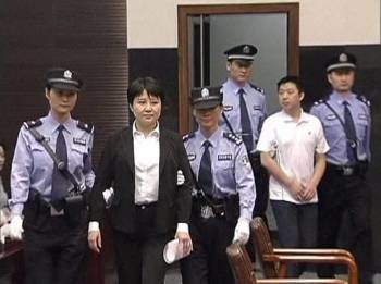 Gu Kailai y su cómplice Zhang Xiaojun, custodiados por agentes de la policía china, ante el tribunal.