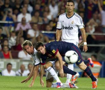 El madridista Coentrao pelea con el barcelonista Messi ante la mirada de Cristiano Ronaldo. (Foto: ALEJANDRO GARCÍA)