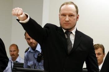 Anders Behring Breivik (c) levanta el puño a su llegada a la sala del tribunal que le juzga en Oslo