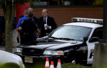 El fiscal del condado de Middlesex, Bruce Kaplan, con varios agentes de policía en el lugar del tiroteo.