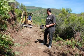 Enrique Álvarez Barreiro, alcalde de Vilamartín, indica a la excavadora el camino que debe seguir. (Foto: LUIS BLANCO)