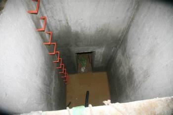 El pozo de la tragedia. Al fondo, la puerta por la que sale el agua desde una mina subterránea. (Foto: A.R.)
