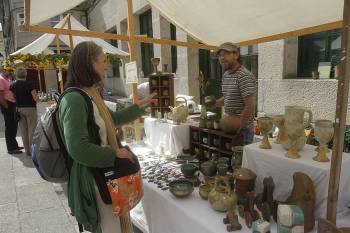 Una visitante se interesa por los productos de cerámica de uno de los puestos del mercado. (Foto: MIGUEL ÁNGEL)
