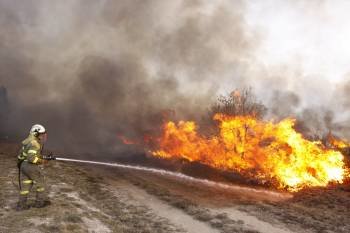 Un bombero trata de sofocar las llamas en un incendio. (Foto: XESÚS FARIÑAS)