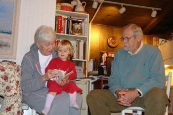 Unos abuelos leen un cuento a su pequeña nieta. (Foto: HOHEM GOUVEIA)