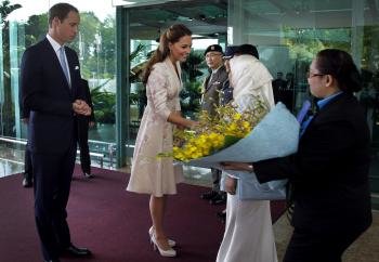 El príncipe Guillermo y su mujer, Catalina, reciben un ramo de flores a su llegada al aeropuerto de Singapur. 