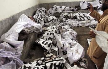Los cuerpos de las víctimas del incendio en una fábrica textil yacen en un deposito de cadáveres en Karachi, Pakistán