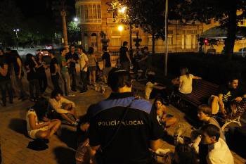 Un policía local identifica a participantes en un botellón en la Alameda de Ourense. (Foto: MIGUEL ÁNGEL)