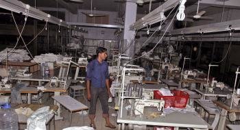  Un hombre observa el interior de la fábrica de textiles incendiada ayer en Karachi, Pakistán, 