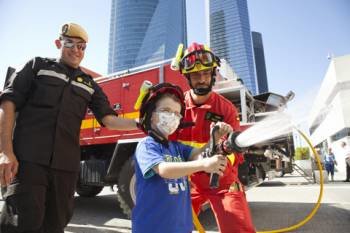 Un niño aprende a ser bombero en una visita de la Unidad Militar de Emergencias al Hospital la Paz de Madrid.