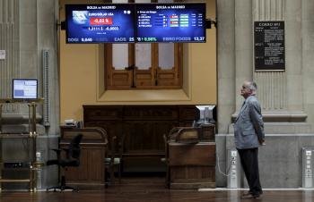 Un hombre ante varias pantallas de la Bolsa de Madrid donde el principal indicador, el IBEX 35 (Foto: EFE)
