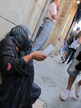 Una mujer sin recursos, uno de los colectivos antedidos por Cáritas,  pide ayuda en la calle. (Foto: EP)
