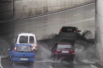 Cuatro coches tratan de atravesar el túnel de Beiramar inundado por las lluvias de ayer. (Foto: LANDÍN)