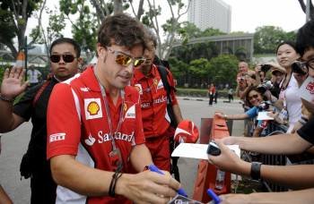 Fernando Alonso firma autógrafos antes de la carrera celebrada ayer en Marina Bay. (Foto: FRANCK ROBICHON)
