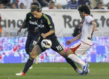 El centrocampista croata del Real Madrid Luka Modric controla el balón ante el defensa del Rayo Vallecano José Manuel Casado (d) (Foto: EFE)