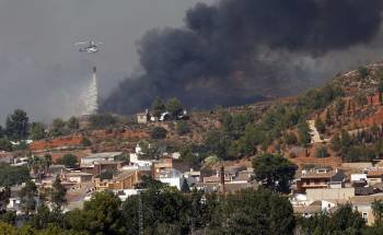 Un helicóptero descarga agua sobre el fuego en Pedralba, uno de los municipios afectados por el incendio.  (Foto: FÖSTERLING)