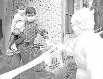 Un médico entrega comida a una familia afectada por la neumonía asiática, en 2003. (Foto: ARCHIVO)