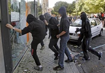 Unos jóvenes golpean un escaparate con motivo de la jornada de huelga general en Pamplona.  (Foto: I. AGUINAGA)