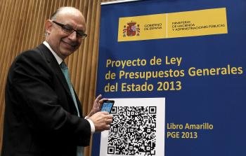  El ministro de Hacienda y Administraciones Públicas, Cristóbal Montoro, posa junto a un cartel con dos códigos QR (Foto: EFE)