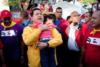 El presidente de Venezuela, Hugo Chávez, carga a una niña durante un acto de campaña. (Foto: M. GUTIÉRREZ)